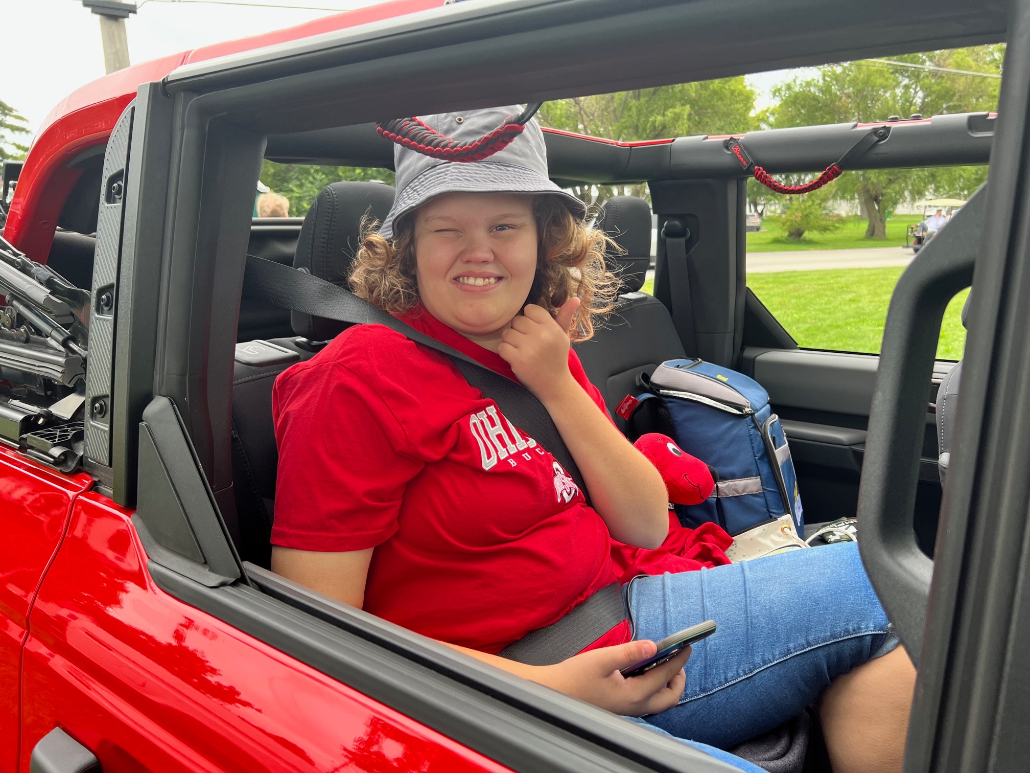 Evie in the back seat of a red Bronco.